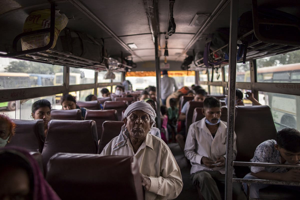 Migrant workers are transported by a state provided bus to their home villages, in New Delhi, India. (Photographer: Anindito Mukherjee/Bloomberg)