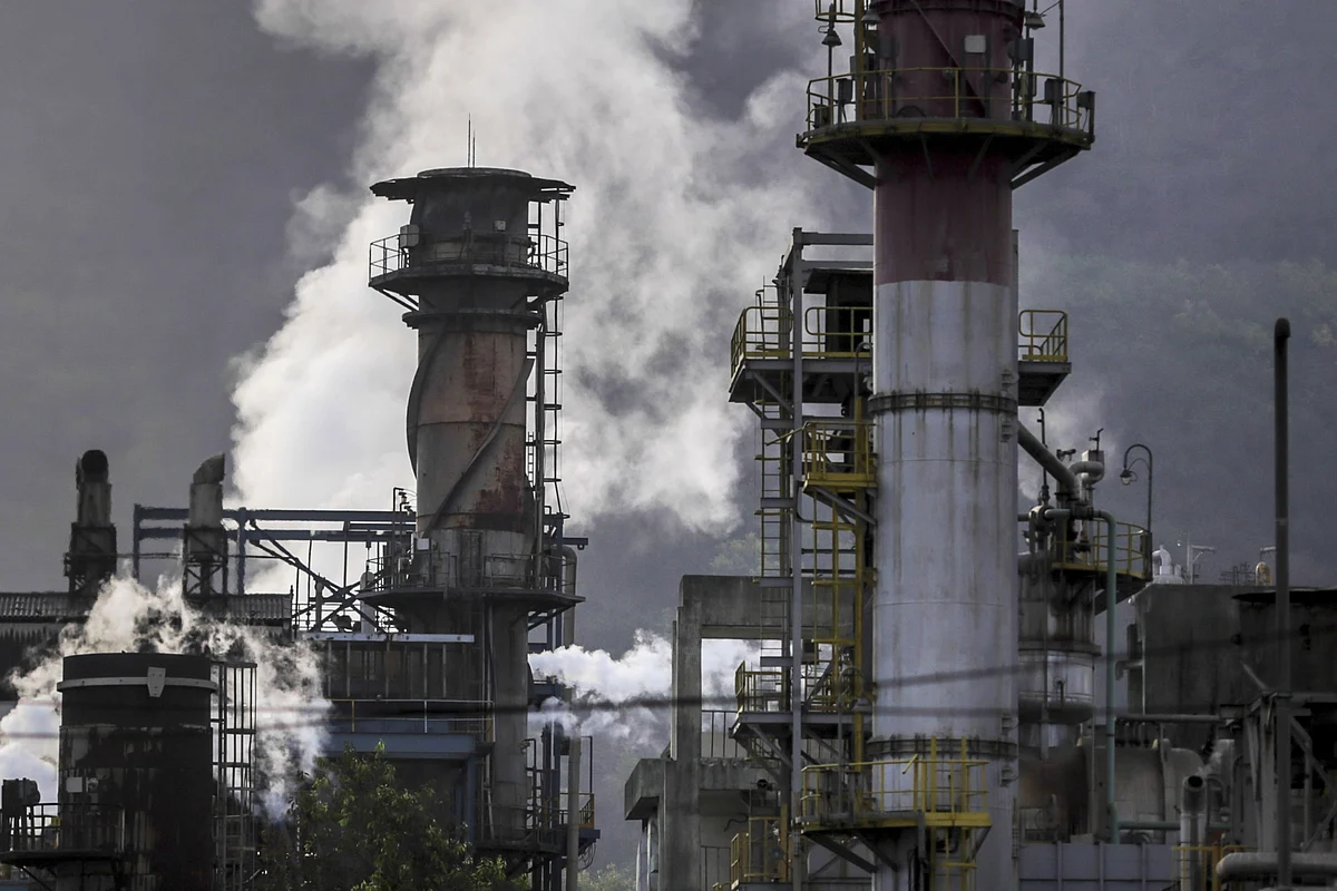 Emissions rise from chimneys at the Oil and Natural Gas Corporation Ltd. Uran plant in India. (Photographer: Dhiraj Singh/Bloomberg)