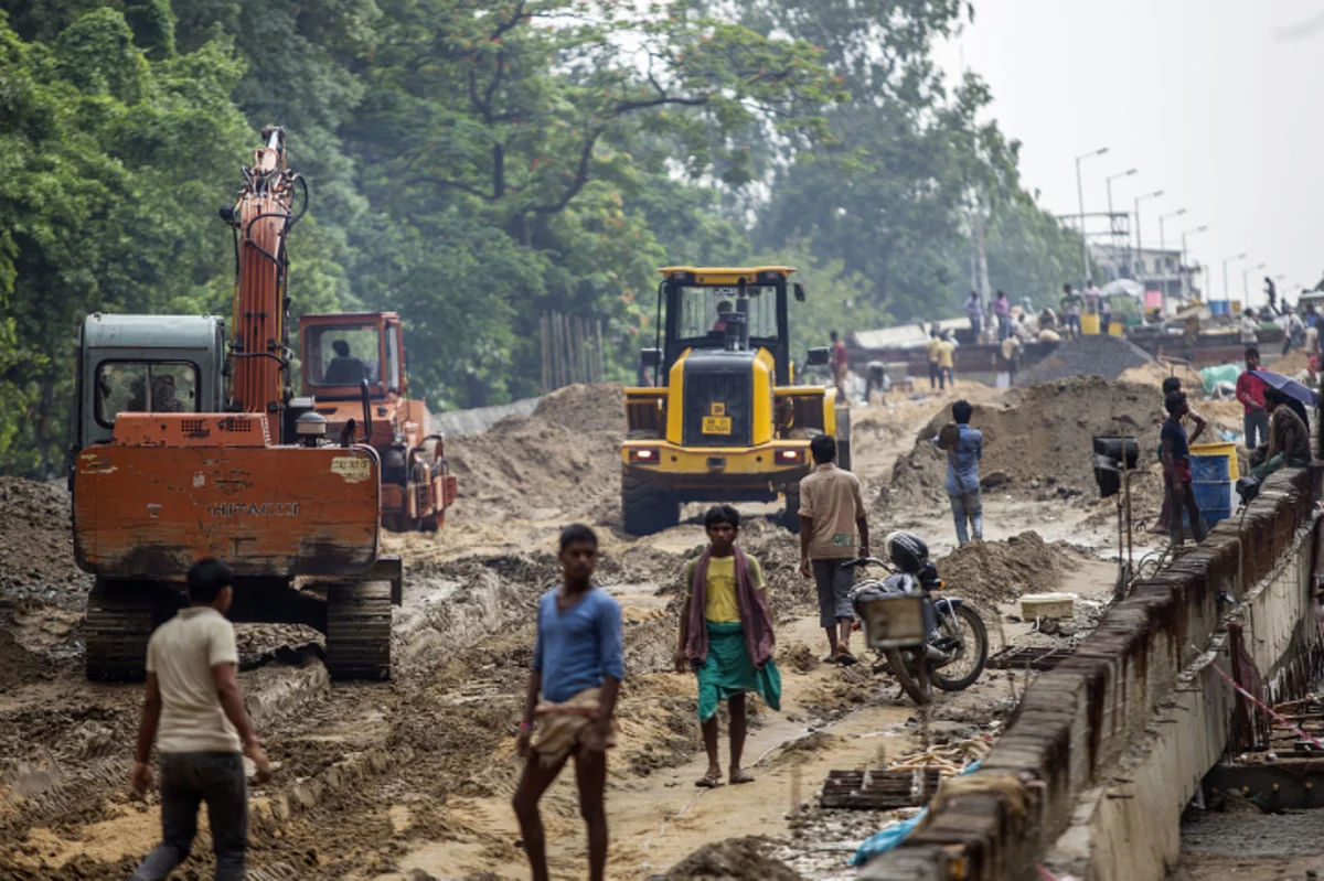 People walk through the construction site for an overpass in Patna, Bihar. (Photographer: Prashanth Vishwanathan/Bloomberg)