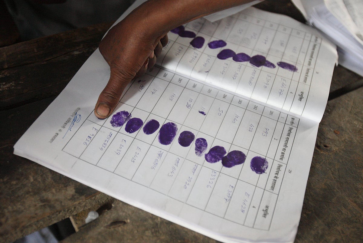 A voter registers with her thumb before casting her ballot paper at the polling station. (Photographer: Pankaj Nangia/Bloomberg News)