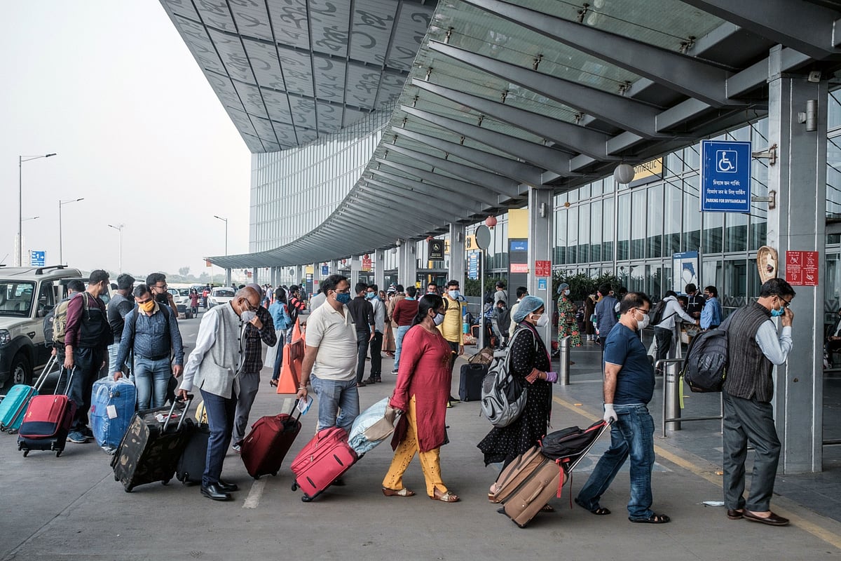 Travelers wearing protective masks arrive at Netaji Subhas Chandra Bose International Airport in Kolkata, on Dec. 6, 2020. (Photographer: Arco Dato/Bloomberg)