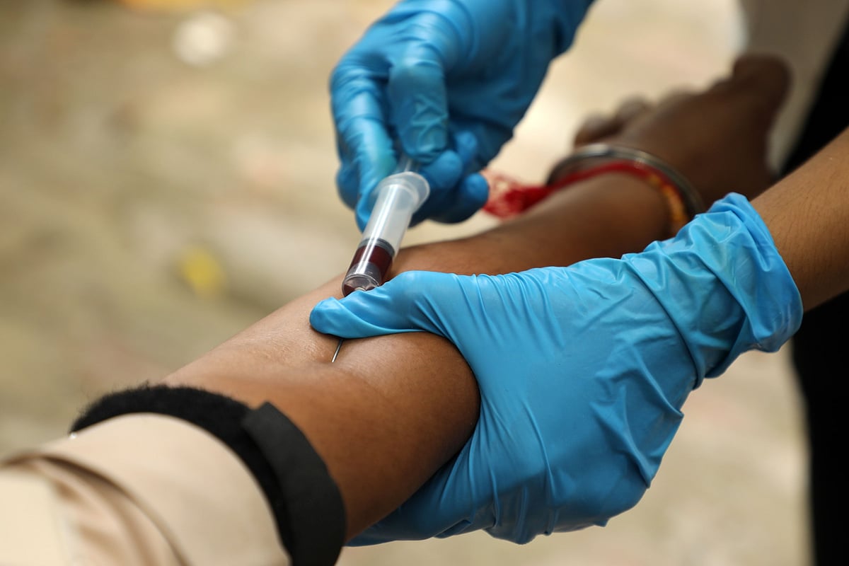 A health worker takes a blood sample  at a serological survey site in New Delhi, on Aug. 6, 2020. (Photographer: T. Narayan/Bloomberg)