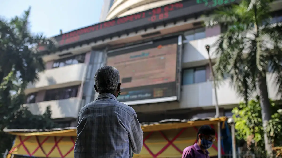<div class="paragraphs"><p>A person looks up at a screen and an electronic ticker board outside the Bombay Stock Exchange building. (Photographer: Dhiraj Singh/Bloomberg)</p></div>