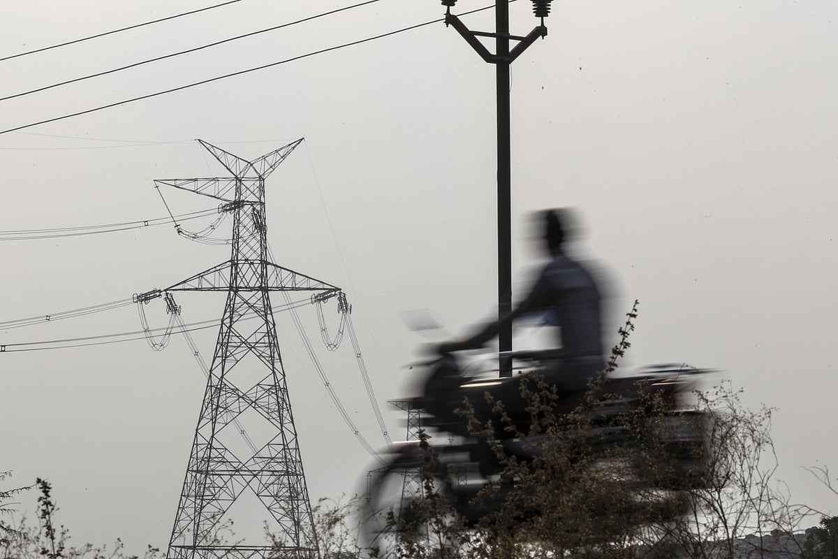<div class="paragraphs"><p>A motorcyclist rides near an electricity transmission pylon operated by MSEDCL in Nandurbar district, Maharashtra. (Photographer: Dhiraj Singh/Bloomberg)</p></div>