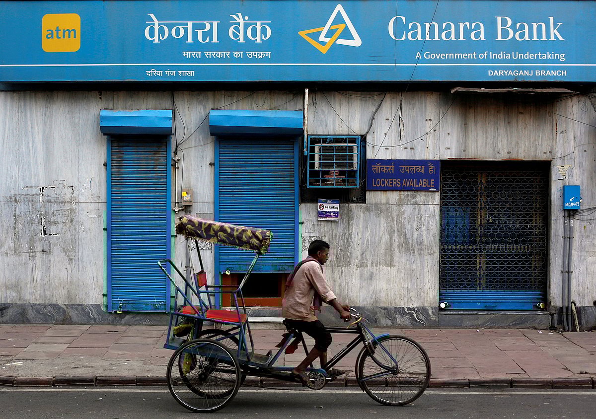 <div class="paragraphs"><p>A rickshaw puller passes a Canara Bank branch in Delhi, India. (Photo: Adnan Abidi/Reuters)</p></div>