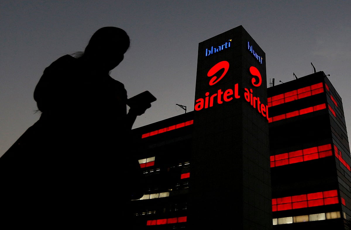 <div class="paragraphs"><p>A girl checks her mobile phone as she walks past the Bharti Airtel office building in Gurugram. (Photo: Adnan Abidi/Reuters)</p></div>
