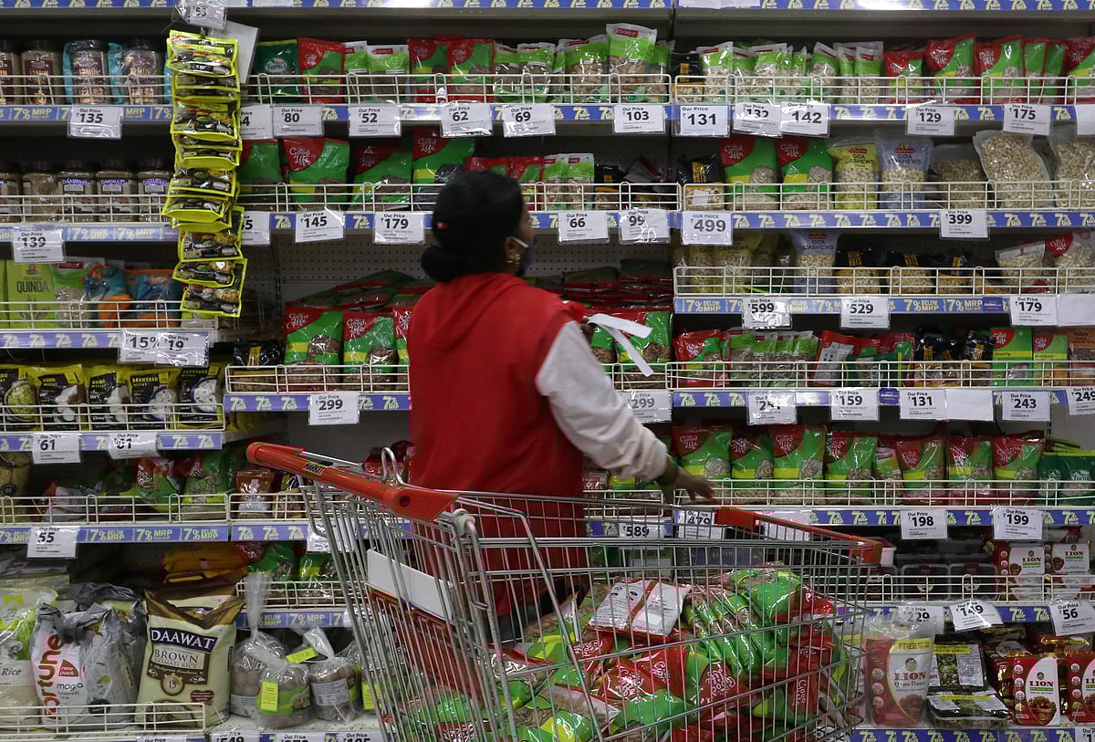 <div class="paragraphs"><p>A worker arranges staple goods inside a Reliance supermarket in Mumbai. (Photo: Niharika Kulkarni/Reuters)</p></div>