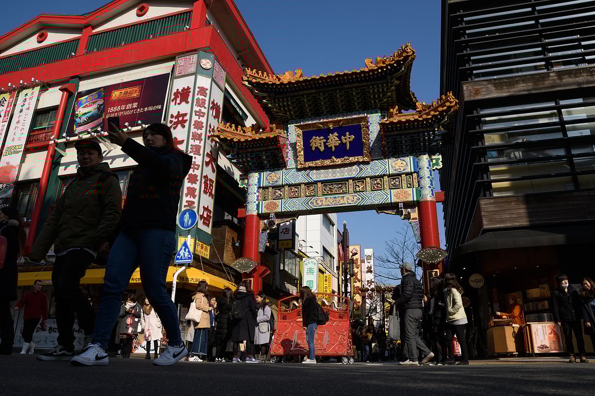 People walk through a gate at the Yokohama Chinatown area of Yokohama.Photographer: Akio Kon/Bloomberg