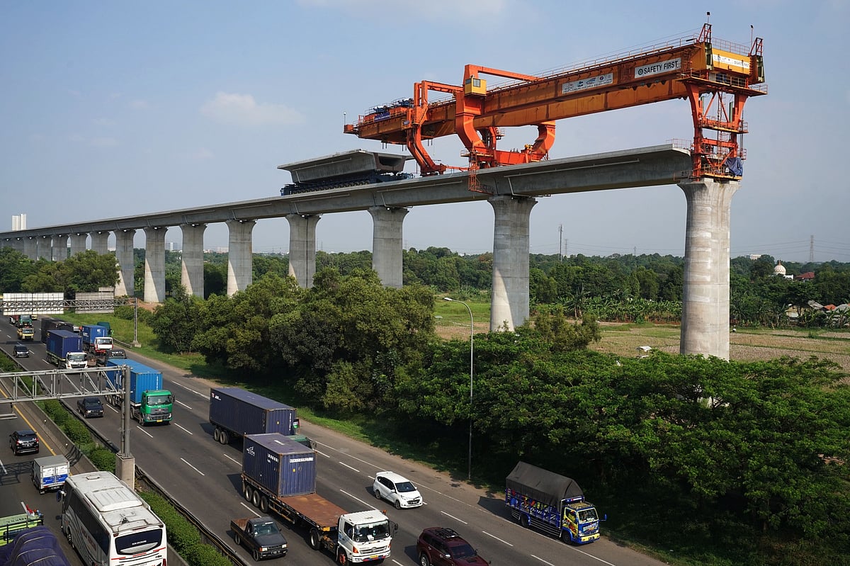 An under construction section of elevated track for the Jakarta-Bandung High-Speed Railway (HSR) runs next to a highway in West Java in 2021.Photographer: Dimas Ardian/Bloomberg