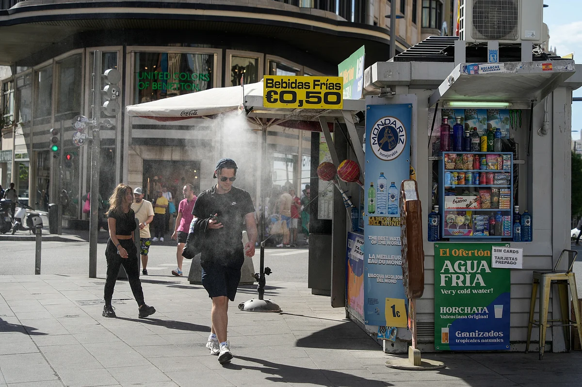 A cooling mist spray from a street kiosk during high temperatures in central Madrid, Spain, earler in April. Photographer: Paul Hanna/Bloomberg