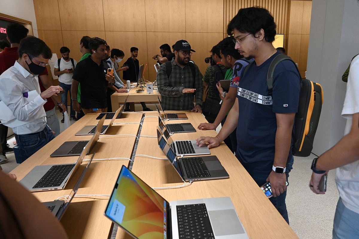 Customers look at Apple Inc. laptop computers at the new Apple Saket store during its opening in New Delhi, India, on Thursday, April 20, 2023. Apple's Chief Executive Officer Tim Cook is to open its second company-owned store in India, following the Mumbai launch on Tuesday, betting the iPhone maker's retail outlets will help accelerate sales growth.