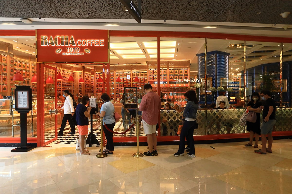 Shoppers wearing protective masks wait to enter Bacha Coffee at Orchard Road in Singapore in 2020.Photographer: Suhaimi Abdullah/Getty Images
