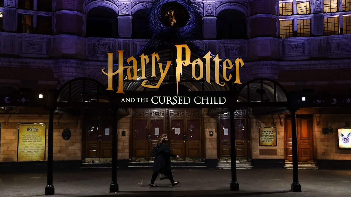 A pedestrian walks past the 'Harry Potter and the Cursed Child' show theatre in the West End district in London, U.K., on Friday, March 20, 2020. A shutdown of the U.K. capital would hit the night-time economy hard -- one in three employees in London works between 6 p.m. and 6 a.m., many in the pubs, restaurants and clubs most at risk of survival because of the pandemic.