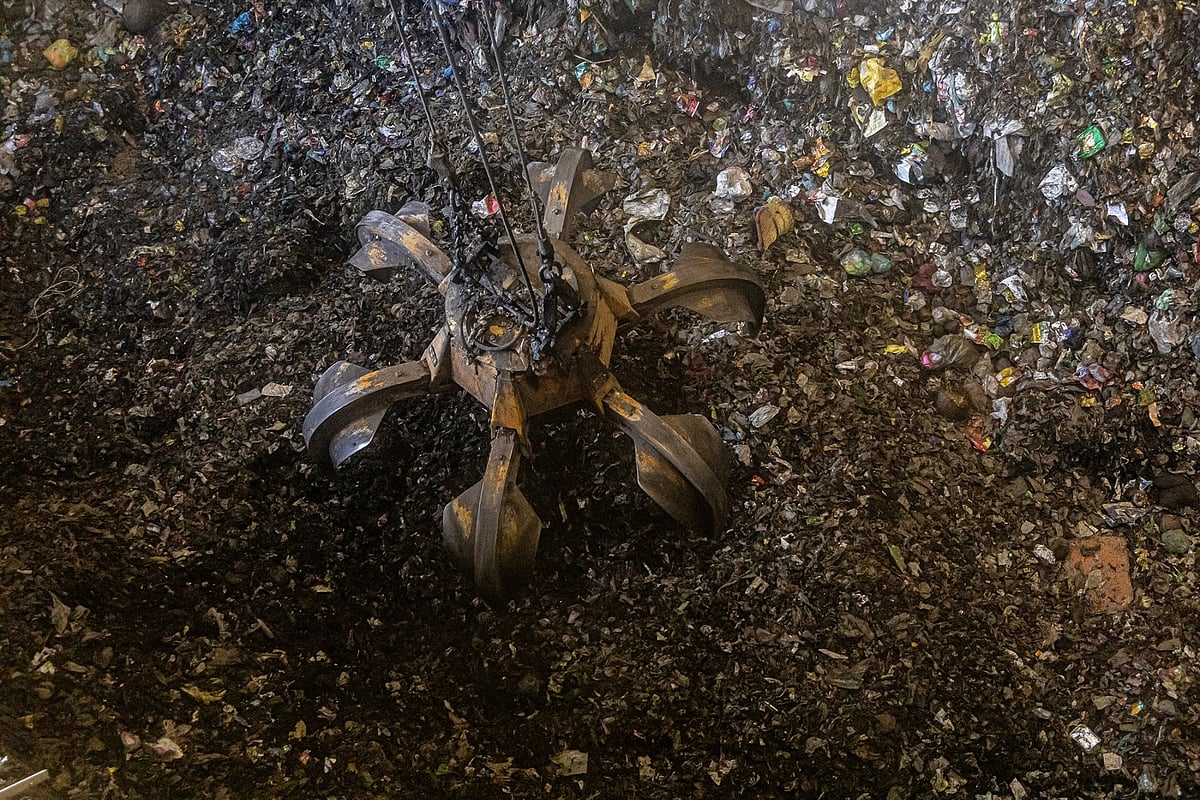 Waste is arranged into tall piles, which are then progressively poured into the boiler.Photographer: Anindito Mukherjee/Bloomberg