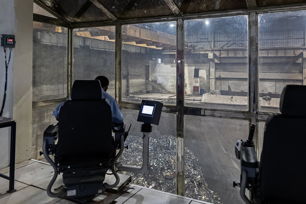 A technician at the JBM Enviro facility operates a grabbing tool.Photographer: Anindito Mukherjee/Bloomberg