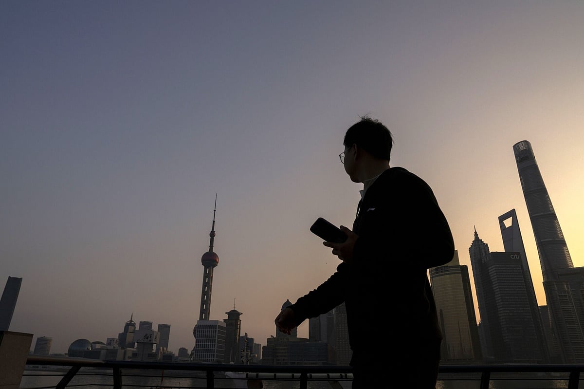 A pedestrian passes buildings in Pudong's Lujiazui Financial District in Shanghai, China, on Monday, Feb. 19, 2024. Chinese stocks saw modest gains as onshore traders returned from the Lunar New Year holidays, with broader caution toward the market offsetting buoyant travel and spending data.