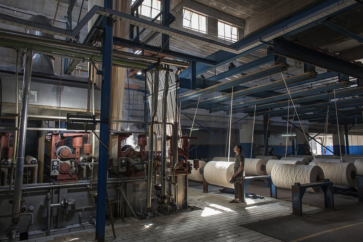 An employee monitors machinery in the dyeing plant of a factory that turns cotton into jeans in Karachi, Pakistan.Photographer: Asim Hafeez/Bloomberg