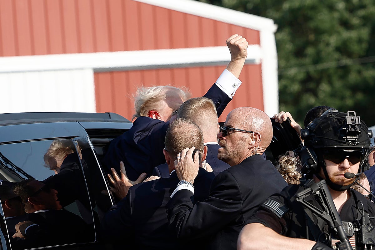 President Donald Trump pumps his fist as he is rushed into a car.Photographer: Anna Moneymaker/Getty Images 