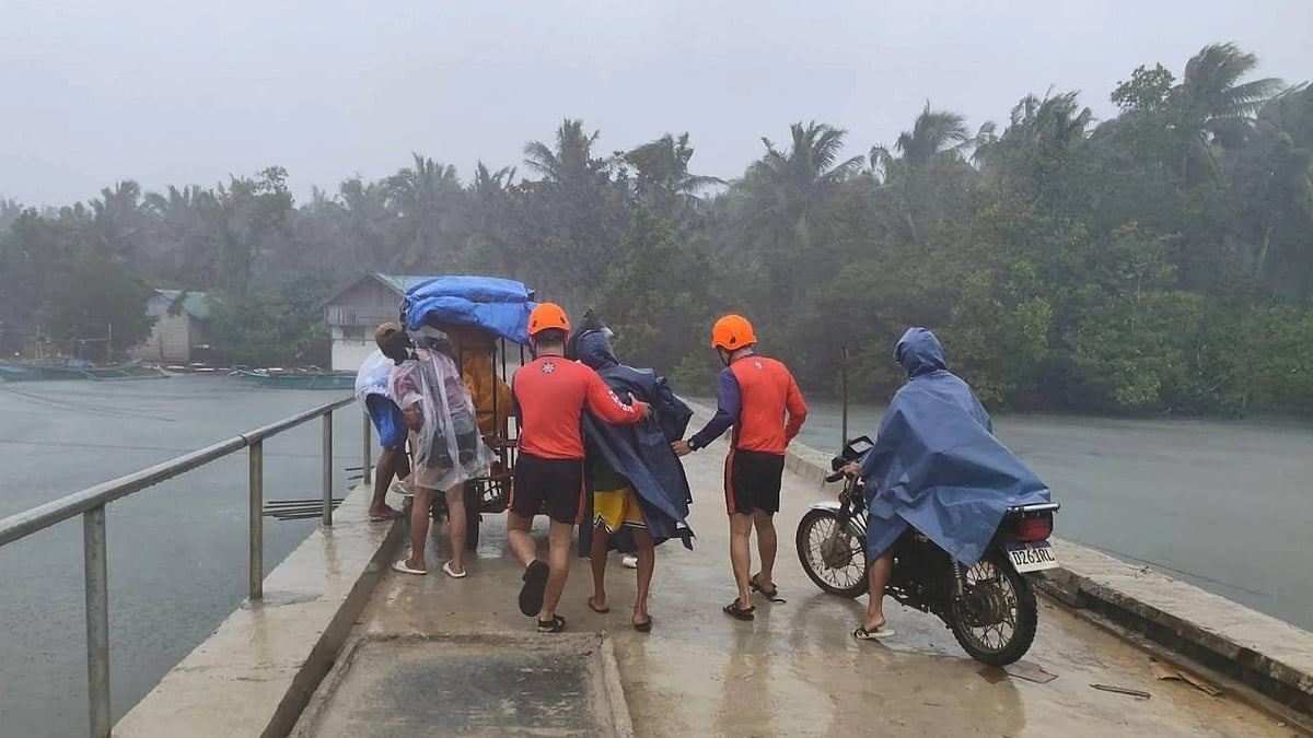 <div class="paragraphs"><p>In this photo provided by the Philippine Coast Guard, rescuers evacuate people to safer grounds in Quezon province, eastern Philippines as Typhoon Fung-wong enters the country on Sunday Nov. 9 2025 (Image: AP/PTI)</p></div>