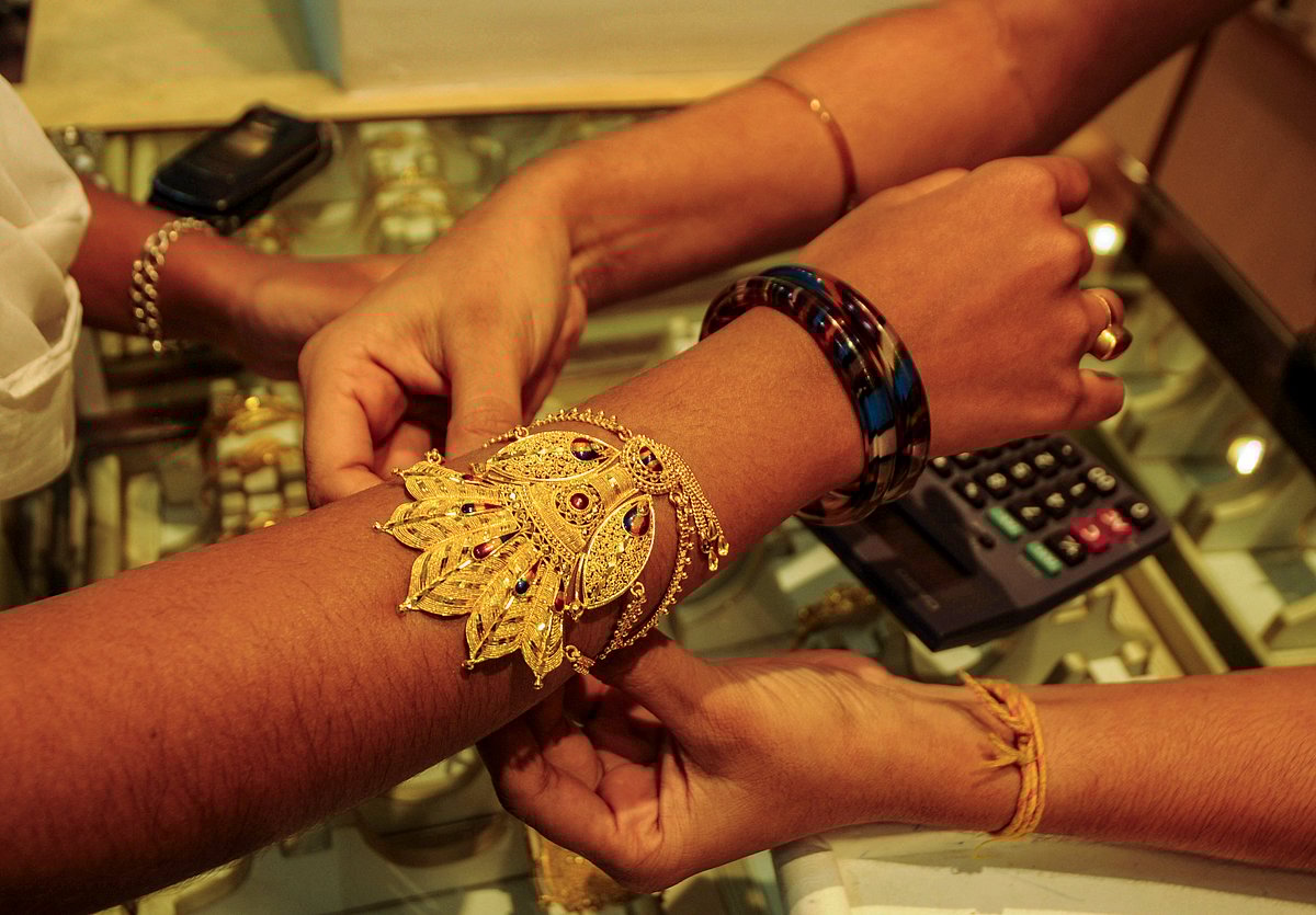 <div class="paragraphs"><p>Agartala: A woman tries a gold ornament at a jewellery showroom ahead of 'Dhanteras' festival, in Agartala, Thursday, Oct. 9, 2025. (PTI Photo)</p></div>