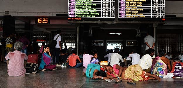 In this photograph taken on June 30, 2014, Indian passengers take a nap inside New Delhi railway station in New Delhi.