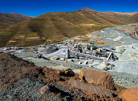 Panoramic view of Lesotho’s Kao diamond mine with open-pit machinery and nearby rural settlements.