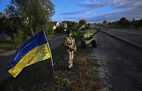 A Ukrainian child holds a mock rifle while manning an improvised checkpoint in the Donetsk region of Ukraine, on 8 September 2022, amid the Russian invasion of Ukraine. (Photo by JUAN BARRETO / AFP)