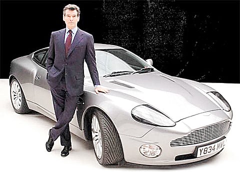 ACTOR Pierce Brosnan as James Bond poses beside the Aston Martin V12 Vanquish.