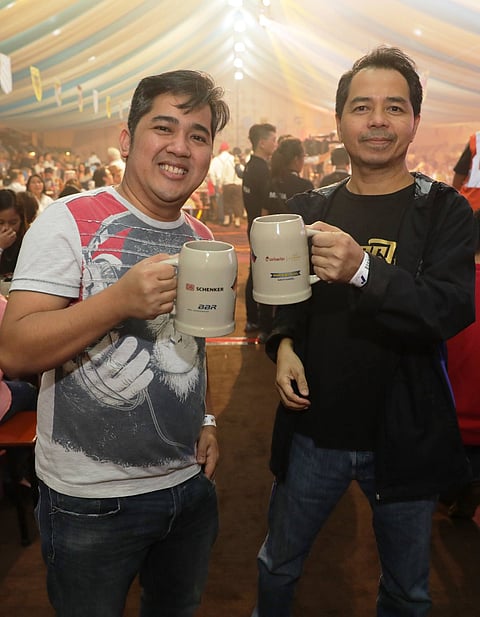 The author, right, having fun with a friend at an Oktoberfest event in Manila.