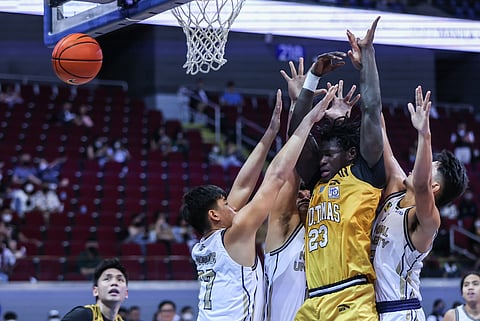 Photograph by Rio deluvio for the Daily Tribune @tribunephl_rio
NU defenders smother Adama Faye of UST during their UAAP Season 85 men’s tournament game yesterday at the Mall of Asia Arena. The Bulldogs won, 67-57.