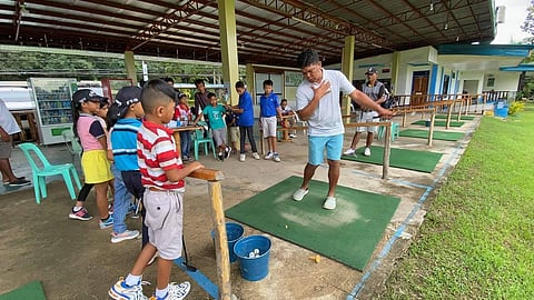 PHOTOgraph COURTESY OF JGFP
Philippine Masters champion Jerson Balasabas shows the proper golf swing to young students at the Edwin Andrews Air Base golf course in Zamboanga City. The ongoing golf clinic is part of the grassroots development program of the Junior Golf Foundation of the Philippines. 