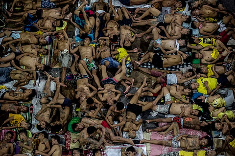 Inmates sleep in an open basketball court inside the Quezon City jail in this 19 July 2016 photo. The jail facility which was built six decades ago for 800 prisoners housed 3,800.  (Photo by NOEL CELIS / AFP)