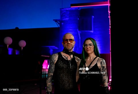 Graphic content / Ronen Shaham, 45, tech engineer from Los Angeles, and his partner Lulu Neel pose after the presentation of label The Code at the Dark Matter venue during the Fashion Week in Berlin on 14 July 2023. (Photo by Tobias SCHWARZ / AFP)