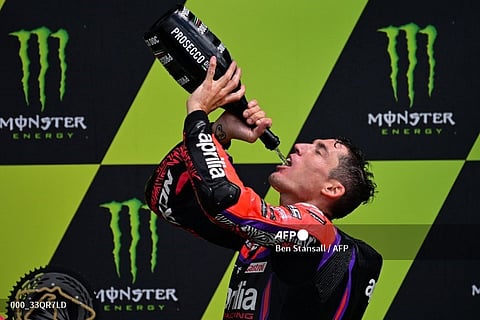 Race winner, Aprilia Racing Spanish rider Aleix Espargaro drinks champagne as he celebrates on the podium at the presentation after the Moto GP race of the motorcycling British Grand Prix at Silverstone circuit in Northamptonshire, central England, on 6 August 2023. (Photo by Ben Stansall / AFP)
