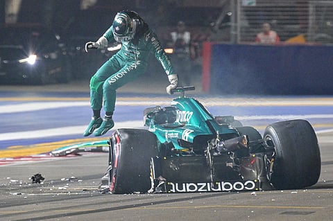 Aston Martin's Canadian driver Lance Stroll jumps out of his car after crashing during the qualifying session of the Singapore Formula One Grand Prix night race at the Marina Bay Street Circuit in Singapore on 16 September 2023. (Photo by CAROLINE CHIA / POOL / AFP)