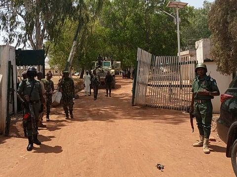Nigerian soldiers and police officers stand at the entrance of the Federal College of Forestry Mechanisation in Mando, Kaduna state, on March 12, 2021, after a kidnap gang stormed the school shooting indiscriminately before taking at least 30 students around 9:30pm (2030 GMT) on March 11, 2021. - Gunmen raided a college in northwestern Nigeria and kidnapped at least 30 students, government officials and parents said on March 12, 2021, in the latest mass abduction targeting a school. (Photo by Bosan Yakusak / AFP)