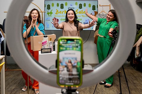 This picture shows Monica Amadea (center), owner of a TikTok sales channel called Monomolly, and her employees offering merchandise through a TikTok livestream in Jakarta. Indonesia has banned goods transactions on social media platforms in a new regulation, its trade minister said on 27 September, as Jakarta aims to rein in direct sales on major platforms it says are harming millions of small businesses. (Photo by BAY ISMOYO / AFP)