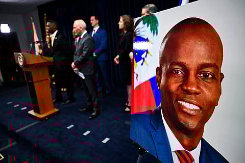 The US Attorney's Office of the Southern District of Florida holds a press conference to announce new arrests and charges in the 7 July 2021, assassination of Haitian President Jovenel Moise (portrait), in Miami on 14 February 2023. (Photo by CHANDAN KHANNA / AFP)