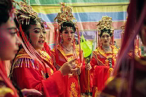 FILE PHOTO: This picture taken on 3 September 2023 shows members of the Jing Sheng Opera rehearsing backstage during the first day of the Hakka Festival at the Yimin temple in Taoyuan. Dressed in a robe fringed with beaded tassels, traditional Taiwanese opera singer Jen Chieh-li applies the final touches to her heavily painted face as she prepares to take the stage. (Photo by Sam Yeh / AFP) 