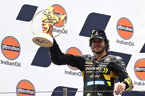 First placed Mooney VR46 Racing Team's Italian rider Marco Bezzecchi poses with the trophy on the podium after the Indian MotoGP Grand Prix at the Buddh International Circuit in Greater Noida on the outskirts of New Delhi, on 24 September 2023. (Photo by Money SHARMA / AFP)