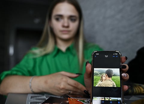 Daryna Voyevodina, 21, shows a photograph of her with her late husband Igor during an interview with AFP in Kyiv on September 14, 2023, amid the Russian invasion of Ukraine. (Photo by Genya SAVILOV / AFP)
