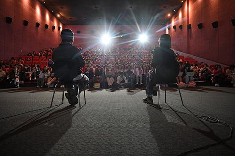 In this photo taken on 7 October 2023, South Korean actor Jung Yoon-suk (L), director of 'Dear Jinri', answers questions during a guest visit event, after a screening of the film at the Busan International Film Festival (BIFF) in Busan. A new documentary featuring a late K-pop star's final interview unveils complex truths about the notoriously brutal K-pop industry and the cost of defying South Korean cultural norms. (Photo by Yelim LEE / AFP)