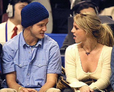 Pop superstars Britney Spears (R) and boyfriend Justin Timberlake (L) talk as they sit courtside at the NBA All-Star Game 10 February 2002 in Philadelphia. Photo by TOM MIHALEK / AFP