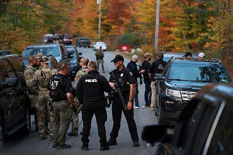 LAW enforcement officials gather in the road leading to the home of the suspect, US Army Reservist Robert Card, who is being sought in connection with two mass shootings on 26 October 2023 in Bowdoin, Maine.