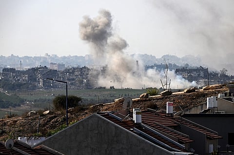 A picture taken from the southern Israeli border city of Sderot shows smoke rising above buildings in the Gaza Strip during an Israeli military operation on November 4, 2023, as battles between Israel and Palestinian Hamas militants continue. Photo by YURI CORTEZ / AFP
