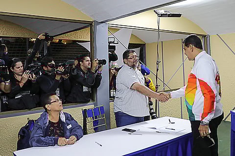 Handout picture released by the Venezuelan Presidency showing Venezuela's President Nicolas Maduro (R) shaking hands with a member of the National Electoral Council during a consultative referendum on Venezuelan sovereignty over the Essequibo region controlled by neighbouring Guyana, in Caracas on 3 December 2023. Venezuela holds a referendum that it hopes will strengthen its century-old claim to the oil-rich Essequibo territory. The referendum includes five questions, including proposals for the creation of a Venezuelan province to be called "Guyana Essequibo," giving the inhabitants Venezuelan citizenship, as well as a call to reject the ICJ's jurisdiction. The dispute over the Essequibo dates back to 1899, when an arbitration court established the border between Venezuela and Guyana, a former colony of Great Britain and the Netherlands. (Photo by MARCELO GARCIA / Venezuelan Presidency / AFP)