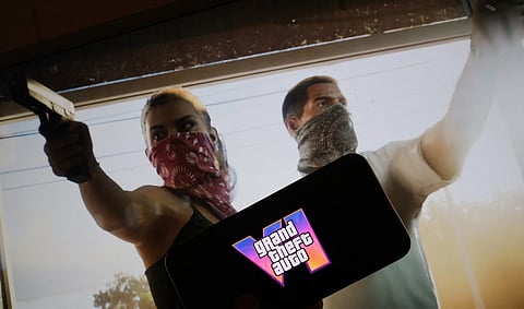 This illustration photo created in Los Angeles, 4 December 2023, shows Rockstar Games Grand Theft Auto VI trailer played on a screen in front of the game title. The first trailer for "Grand Theft Auto VI" was officially released ahead of schedule December 4, 2023 due to a leak, touting a 2025 release for the next chapter of the massively successful video game franchise. (Photo by Chris DELMAS / AFP)