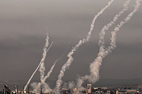 FILE PHOTO: This picture taken from the southern Gaza Strip shows a salvo of rockets fired at Israel and smoke trails on 3 December 2023. (Photo by SAID KHATIB / AFP)