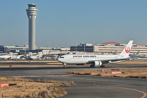 FILE PHOTO: This photo taken on 29 December 2023 shows a Japan Airlines (JAL) passenger plane taxiing past the control tower after its arrival at Tokyo International Airport at Haneda in Tokyo. (Photo by Richard A. Brooks / AFP)