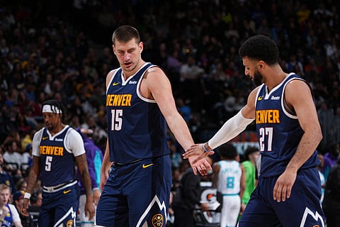 DENVER, CO - 1 JANUARY: Nikola Jokic #15 of the Denver Nuggets high fives Jamal Murray #27 of the Denver Nuggets during the game against the Charlotte Hornets on 1 January 2024 at the Ball Arena in Denver, Colorado. (Photo by Garrett Ellwood / NBAE / Getty Images / Getty Images via AFP)